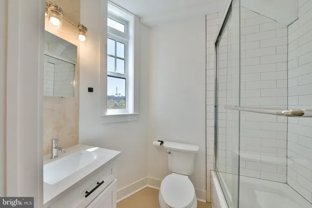 a bathroom with a toilet a sink and mirror