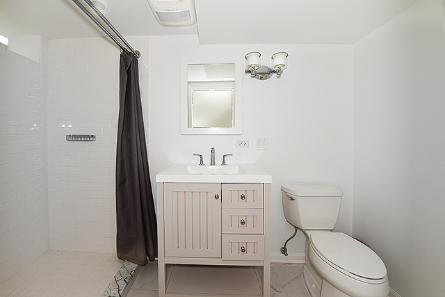 596 Arbor Vitae Road Winnetka, IL 60093 - Photo 50 of 62 a bathroom with a toilet a sink a mirror and vanity