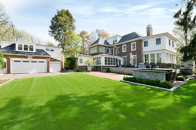 596 Arbor Vitae Road Winnetka, IL 60093 - Photo 56 of 62 a front view of a house with a yard table and chairs