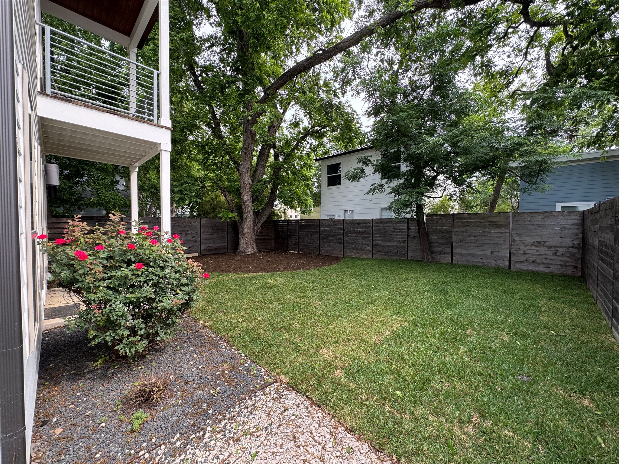 2811 Garwood Street, Unit B Austin, TX 78702 - Photo 24 of 24 Expansive backyard featuring a lush lawn, mature trees, and a wooden privacy fence