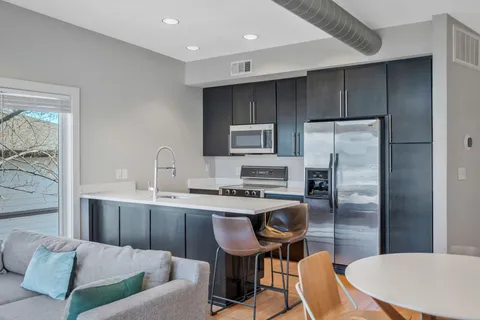 a kitchen with a table chairs refrigerator and microwave