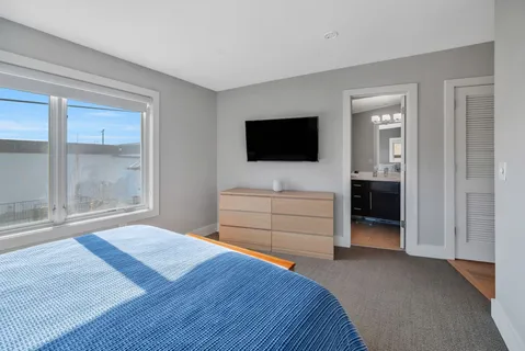 a bedroom with a bed and a flat screen tv