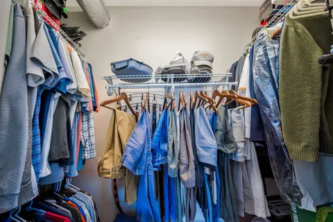 a view of walk in closet with clothes and shoes