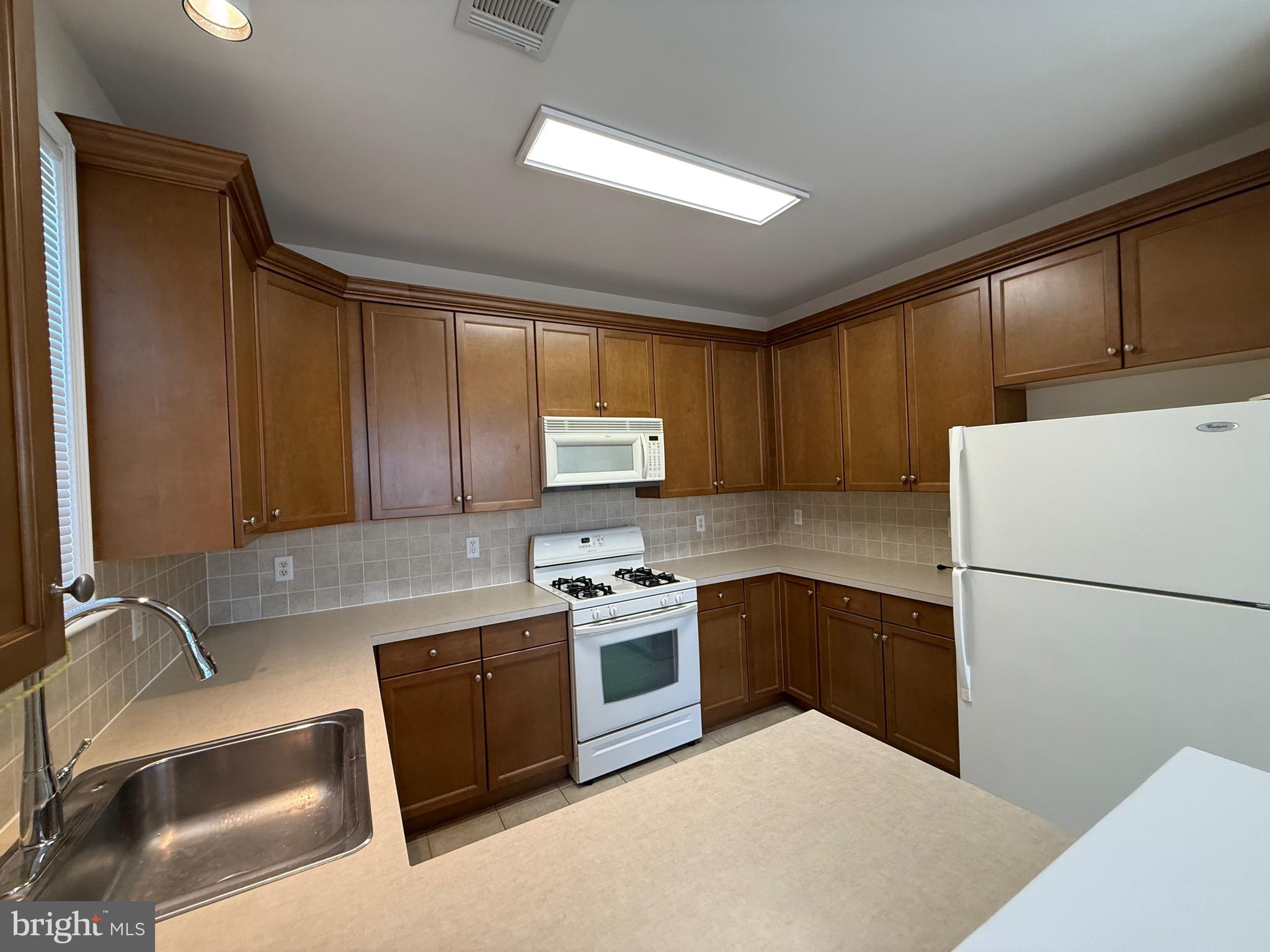 231 Masterson Court Ewing, NJ 08618 - Photo 14 of 43 a kitchen with a sink a stove and refrigerator