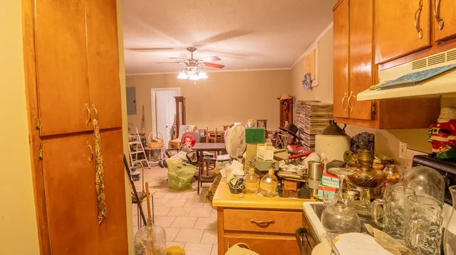 a view of a white house with large windows and wooden fence