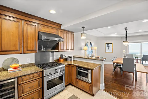 a kitchen with stainless steel appliances a stove a sink dishwasher and cabinets with wooden floor