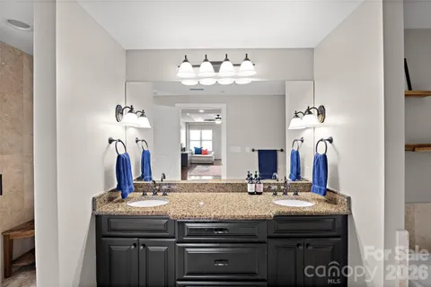 a bathroom with a granite countertop sink and a mirror