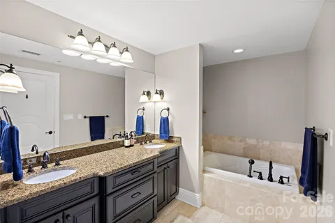 a bathroom with a granite countertop sink a large mirror and shower