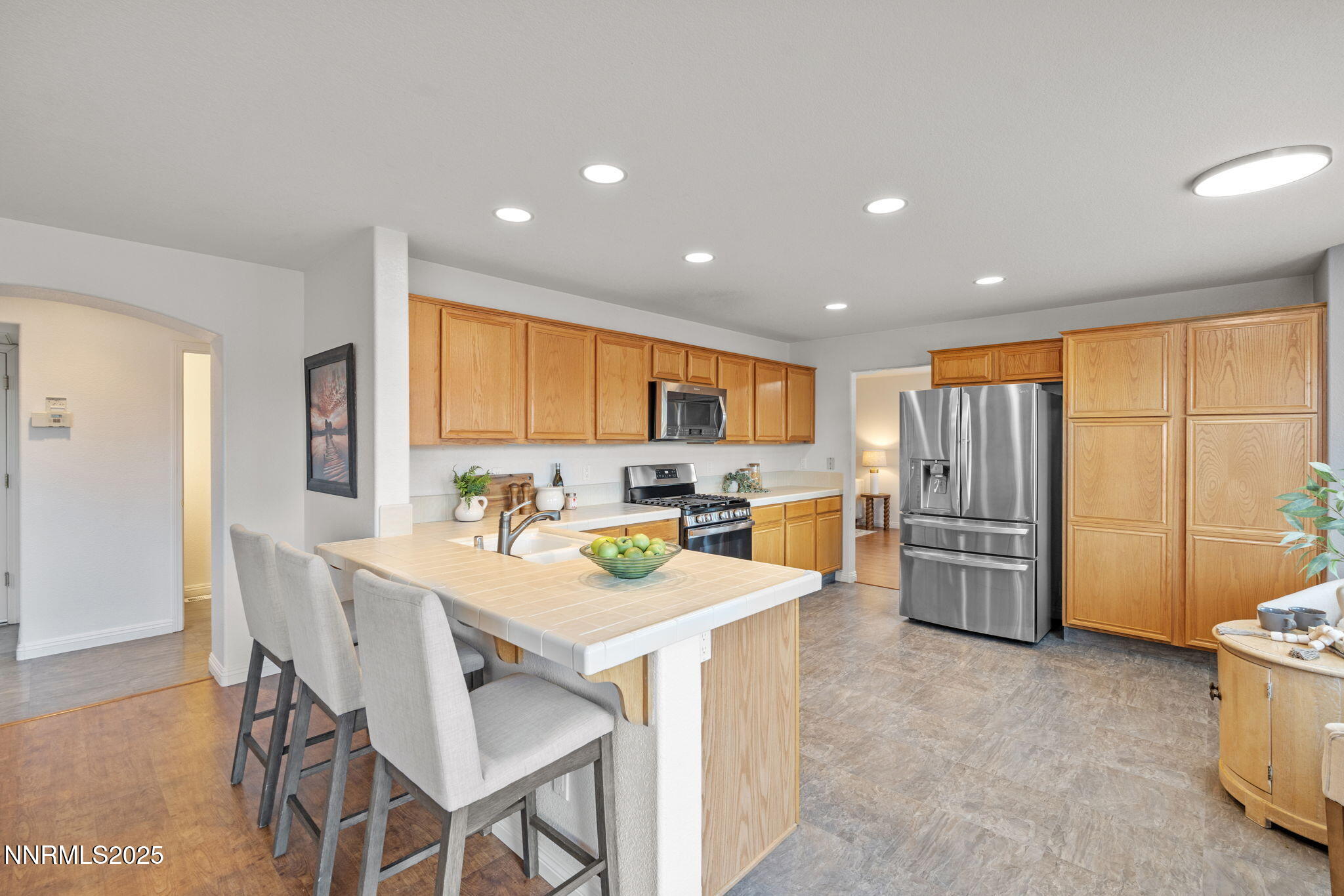 485 Corvallis Court Reno, NV 89511 - Photo 8 of 34 a kitchen with stainless steel appliances kitchen island granite countertop a refrigerator a stove a sink a dining table and chairs with wooden floor