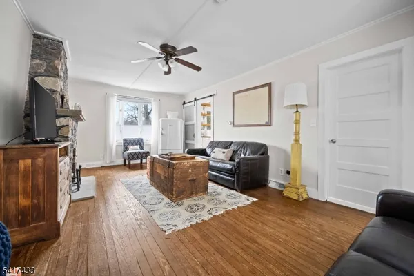 a living room with furniture a flat screen tv and a window