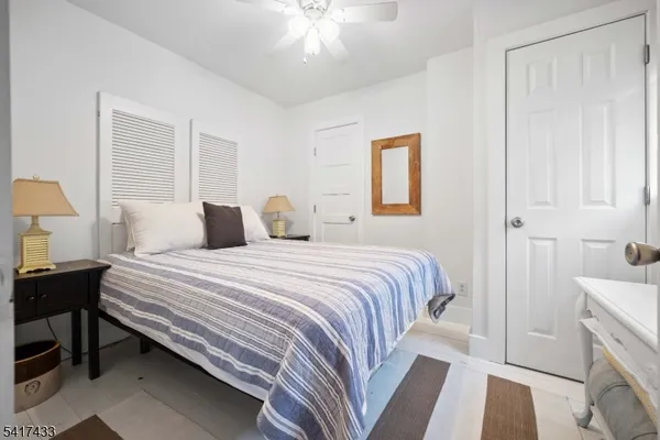 a bedroom with a bed and a lamp on the dresser