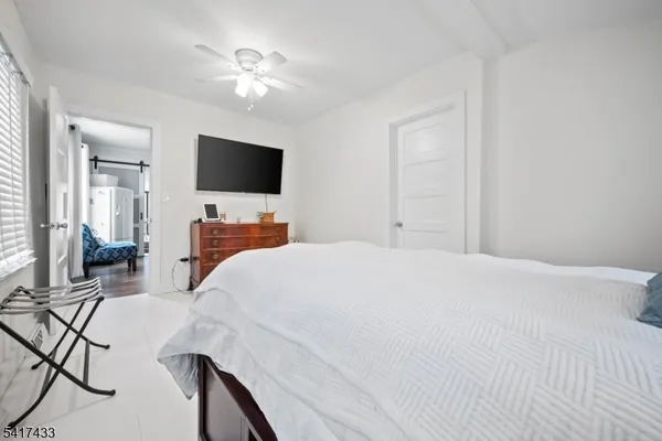 a bedroom with a bed window and a flat screen tv