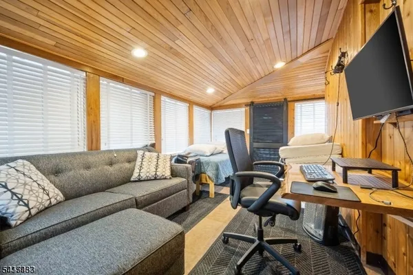 a living room with furniture a flat screen tv and a window