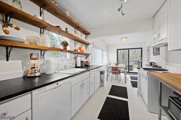 a kitchen with lots of counter space and view of living room