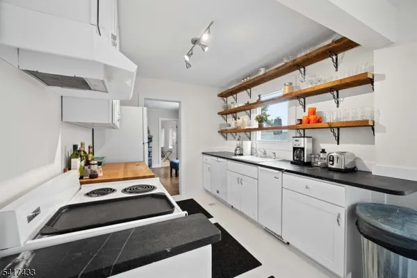 a kitchen with stainless steel appliances a stove a sink and cabinets