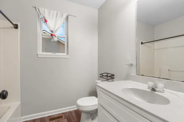a bathroom with a granite countertop toilet sink and mirror