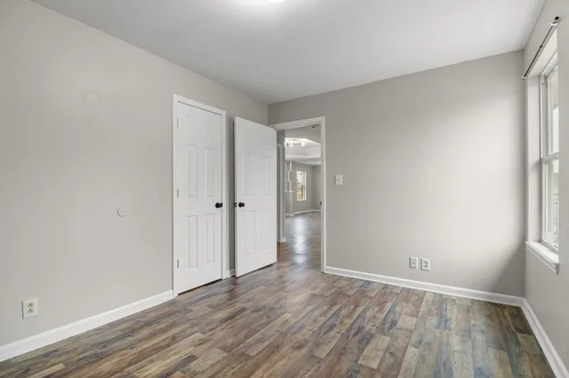 wooden floor in an empty room with a window