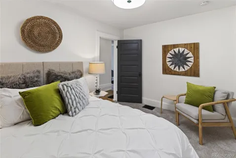 a bedroom with a bed and painting on the wall