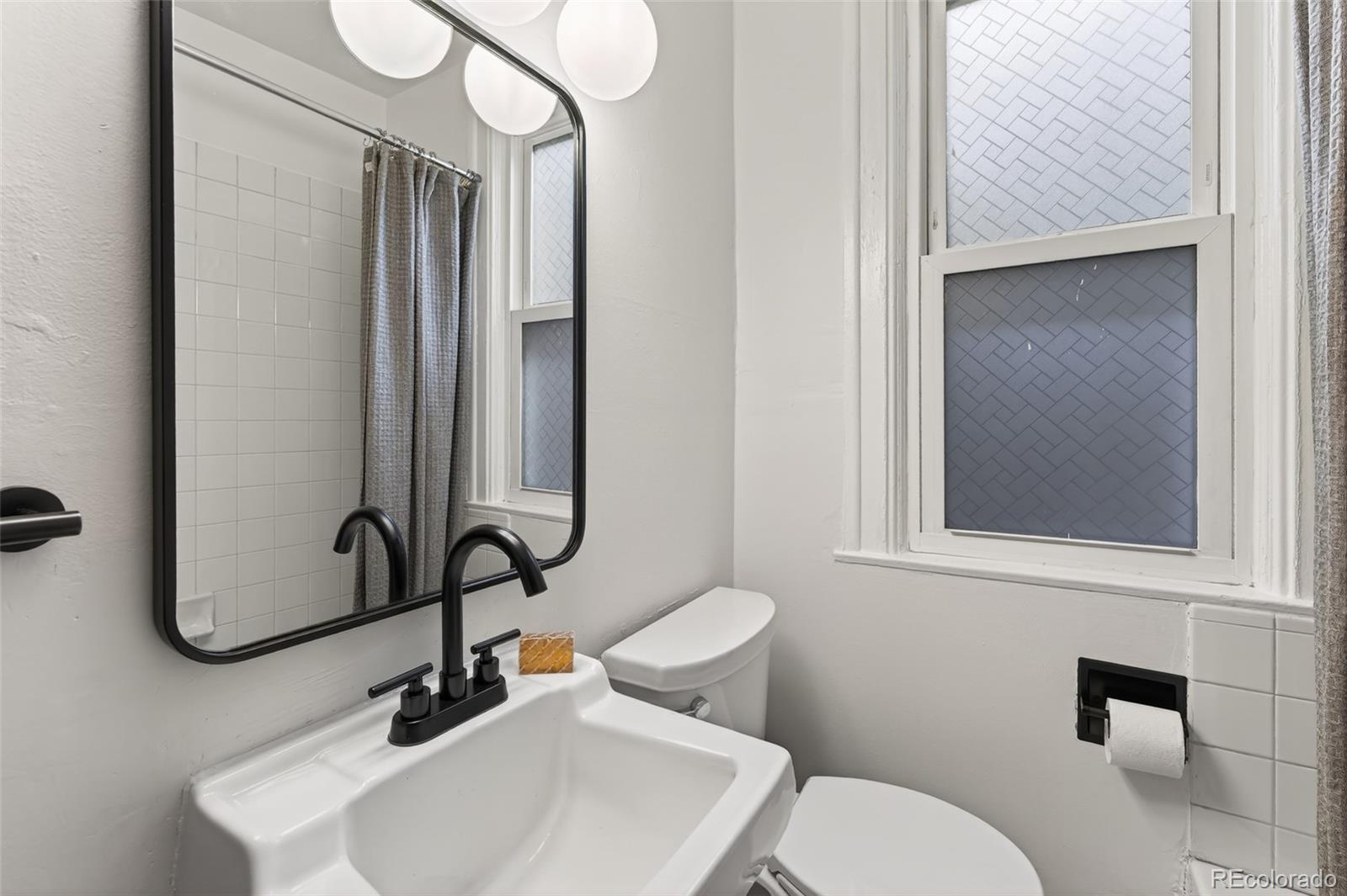 551 Cherokee Street Denver, CO 80204 - Photo 20 of 25 a bathroom with a toilet sink and mirror