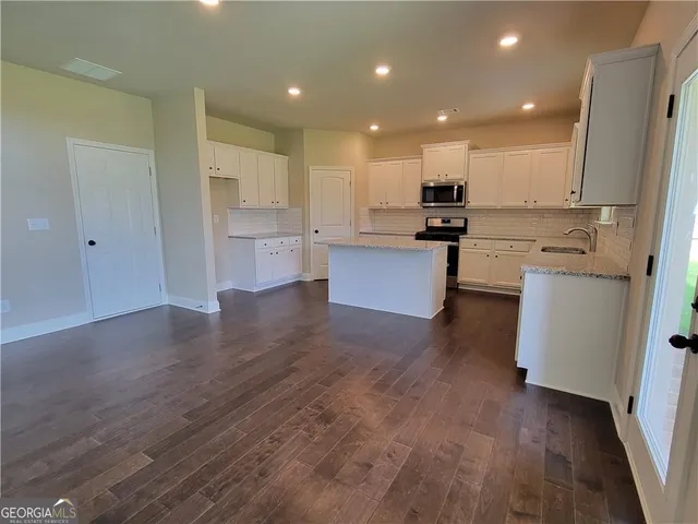 a view of kitchen with stainless steel appliances refrigerator stove microwave and cabinets