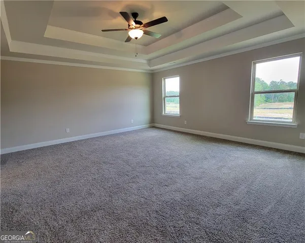 an empty room with a window and a ceiling fan