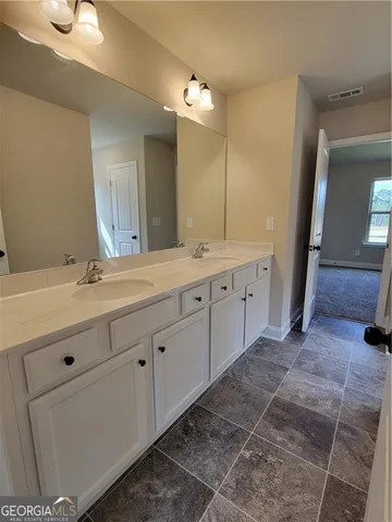 a spacious bathroom with a double vanity sink and a mirror