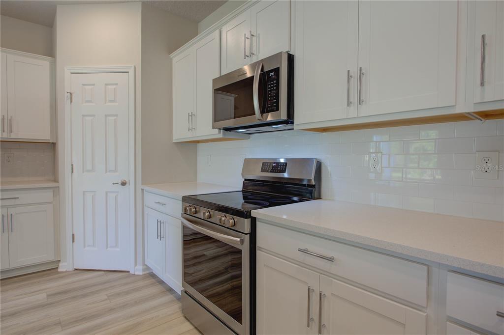 10 Freneau Lane Palm Coast, FL 32137 - Photo 13 of 29 a kitchen with white cabinets and stainless steel appliances