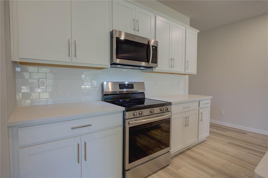 10 Freneau Lane Palm Coast, FL 32137 - Photo 14 of 29 a kitchen with stainless steel appliances white cabinets and a stove top oven