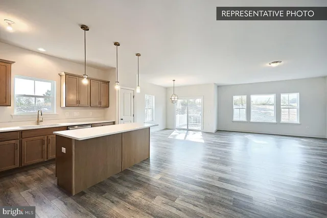 a large kitchen with kitchen island a sink wooden floor and white appliances