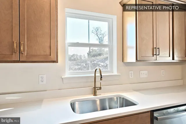 a close view of a sink and dishwasher next to a window