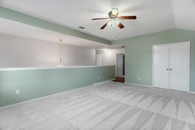 a view of an empty room with a ceiling fan