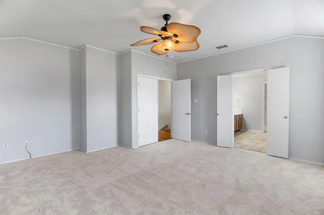 a view of an empty room and a chandelier fan