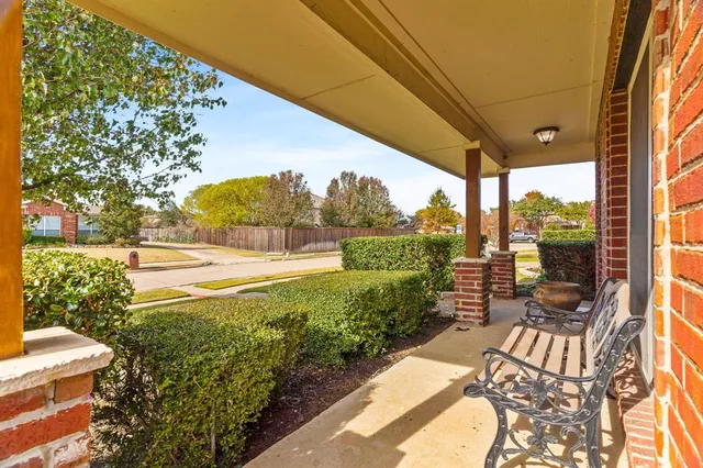 a view of a patio with table and chairs potted plants and floor to ceiling window