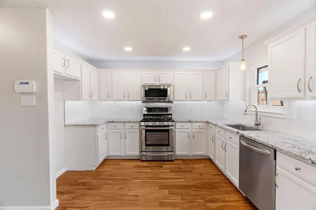 a kitchen with stainless steel appliances granite countertop a stove sink and cabinets