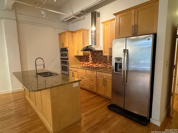 a kitchen with granite countertop a refrigerator and a sink