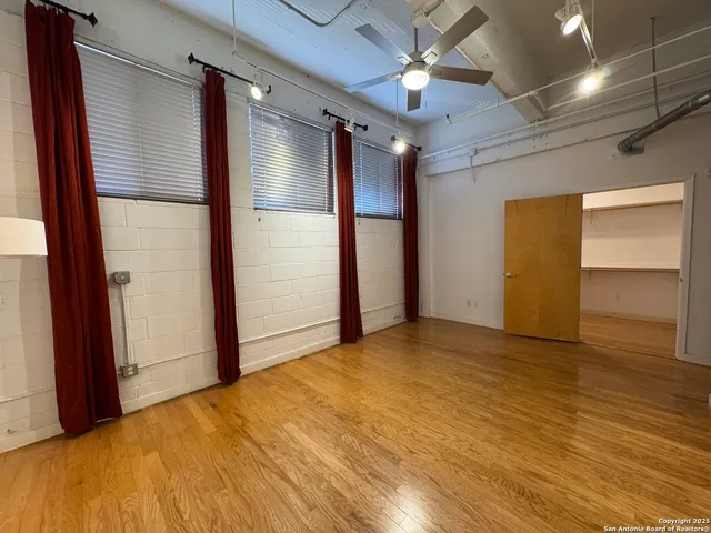 a view of empty room with wooden floor