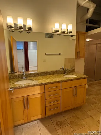 a bathroom with a granite countertop sink and a mirror