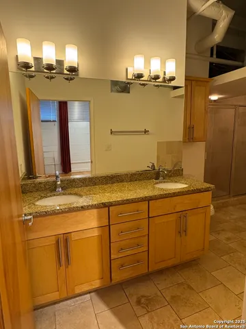 a bathroom with a granite countertop sink and a mirror