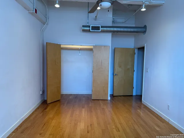 an empty room with wooden floor and closet