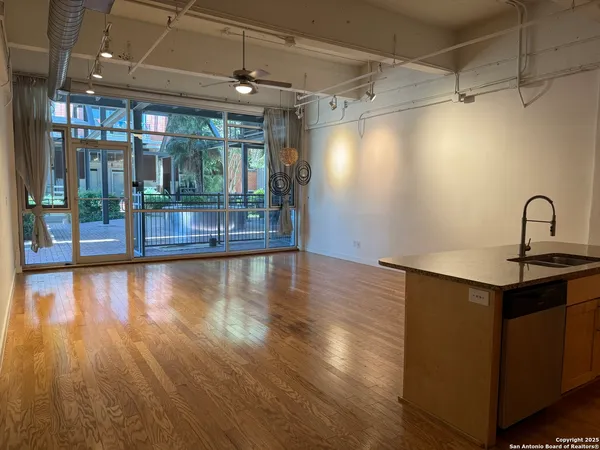 a kitchen with a sink and wooden floor