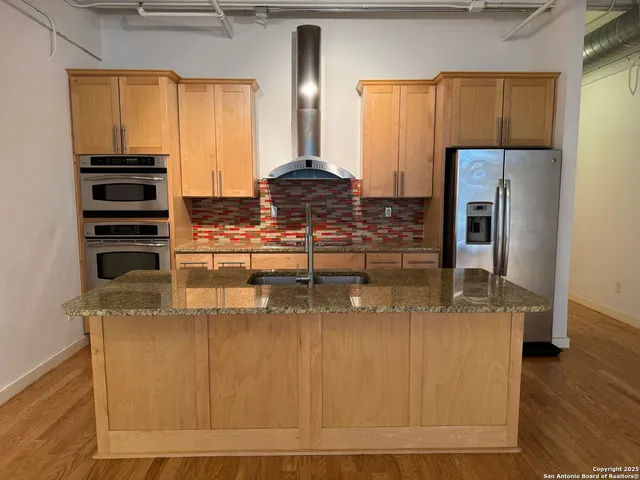 a kitchen with kitchen island granite countertop a stove and a refrigerator