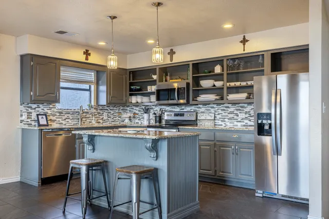 a kitchen with stainless steel appliances granite countertop a sink and a refrigerator