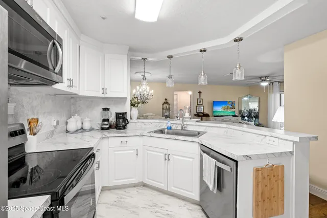 a kitchen with stainless steel appliances a stove top oven a sink dishwasher and a refrigerator