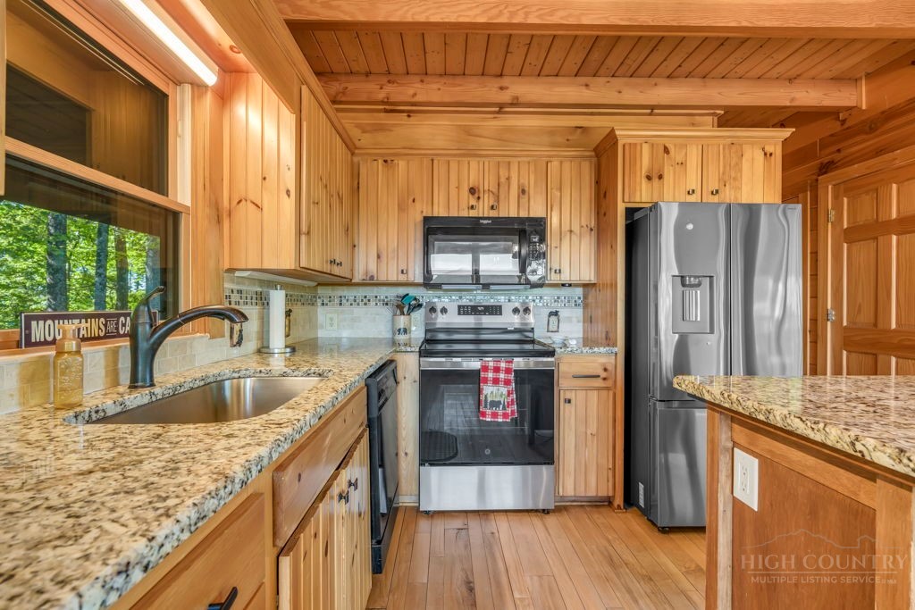 2229 Elk Ridge Road Ferguson, NC 28624 - Photo 13 of 42 a kitchen with stainless steel appliances granite countertop a sink stove and refrigerator