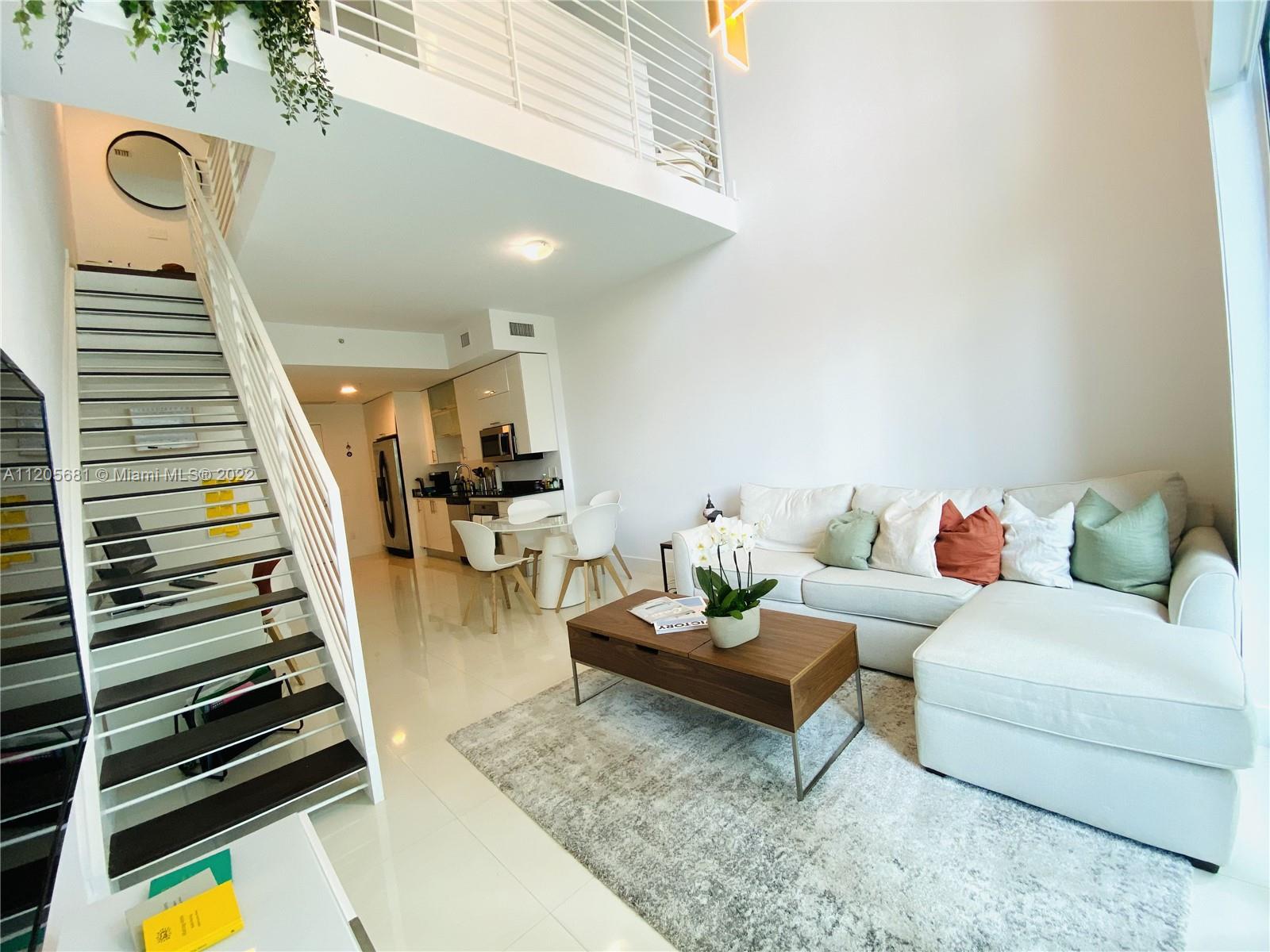 60 Southwest 13th Street, Unit 1412 Miami, FL 33130 - Photo 1 of 39 a living room with furniture and wooden floor