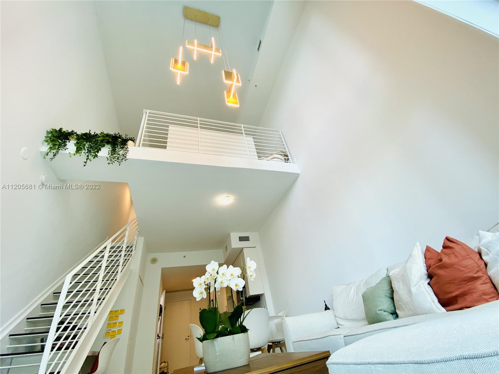 60 Southwest 13th Street, Unit 1412 Miami, FL 33130 - Photo 13 of 39 a living room with furniture and a chandelier