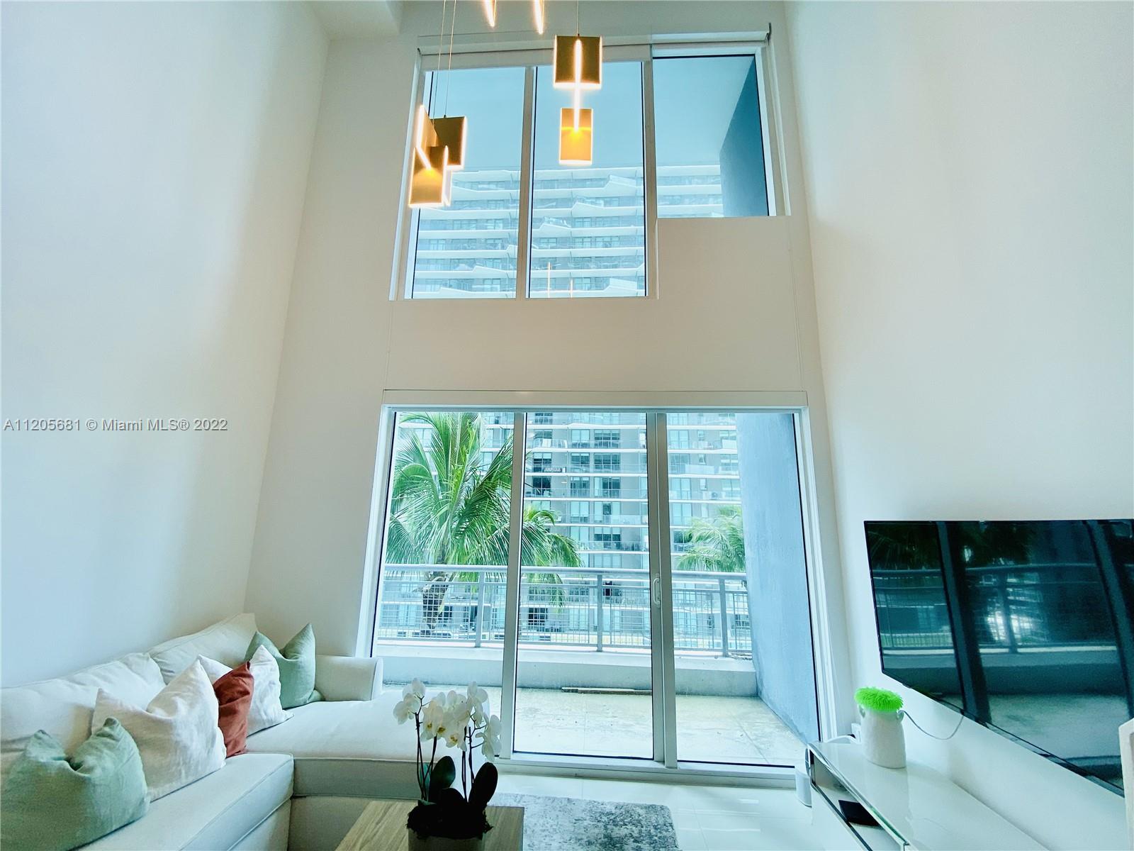 60 Southwest 13th Street, Unit 1412 Miami, FL 33130 - Photo 14 of 39 a living room with furniture and a floor to ceiling window