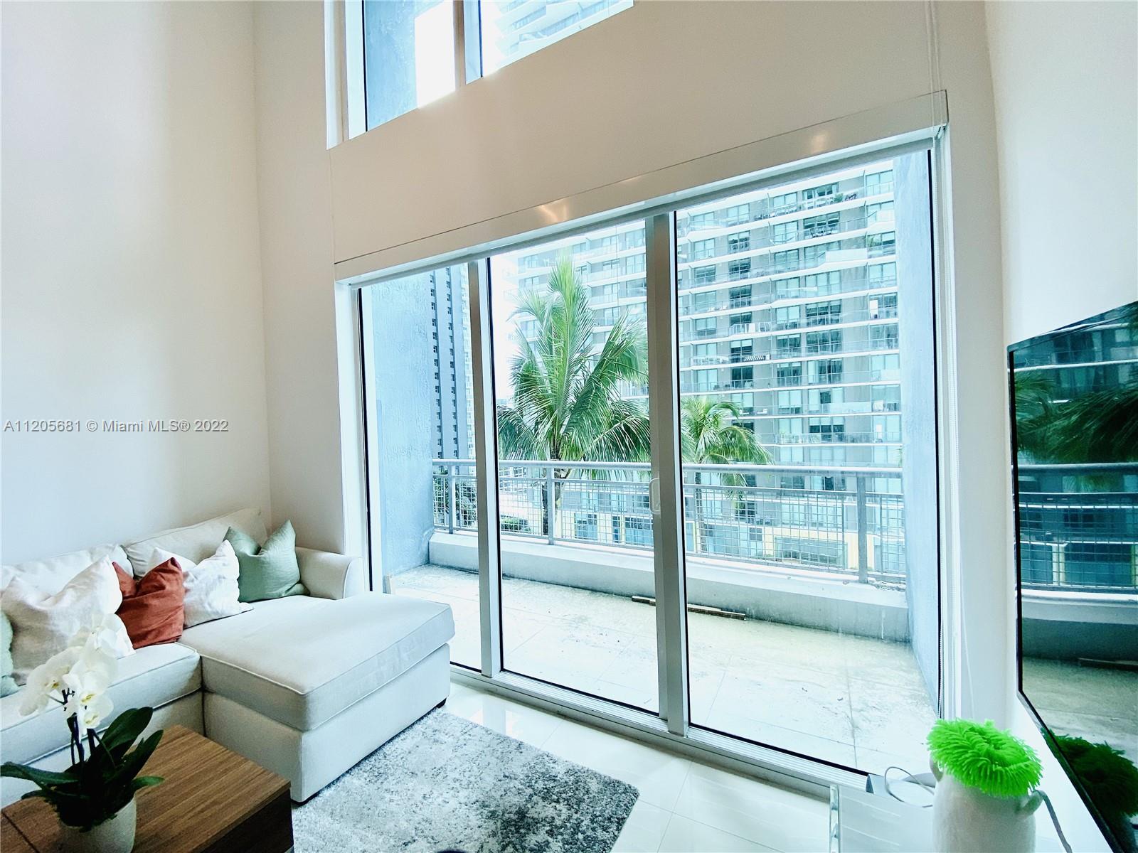60 Southwest 13th Street, Unit 1412 Miami, FL 33130 - Photo 15 of 39 a living room with furniture and a window