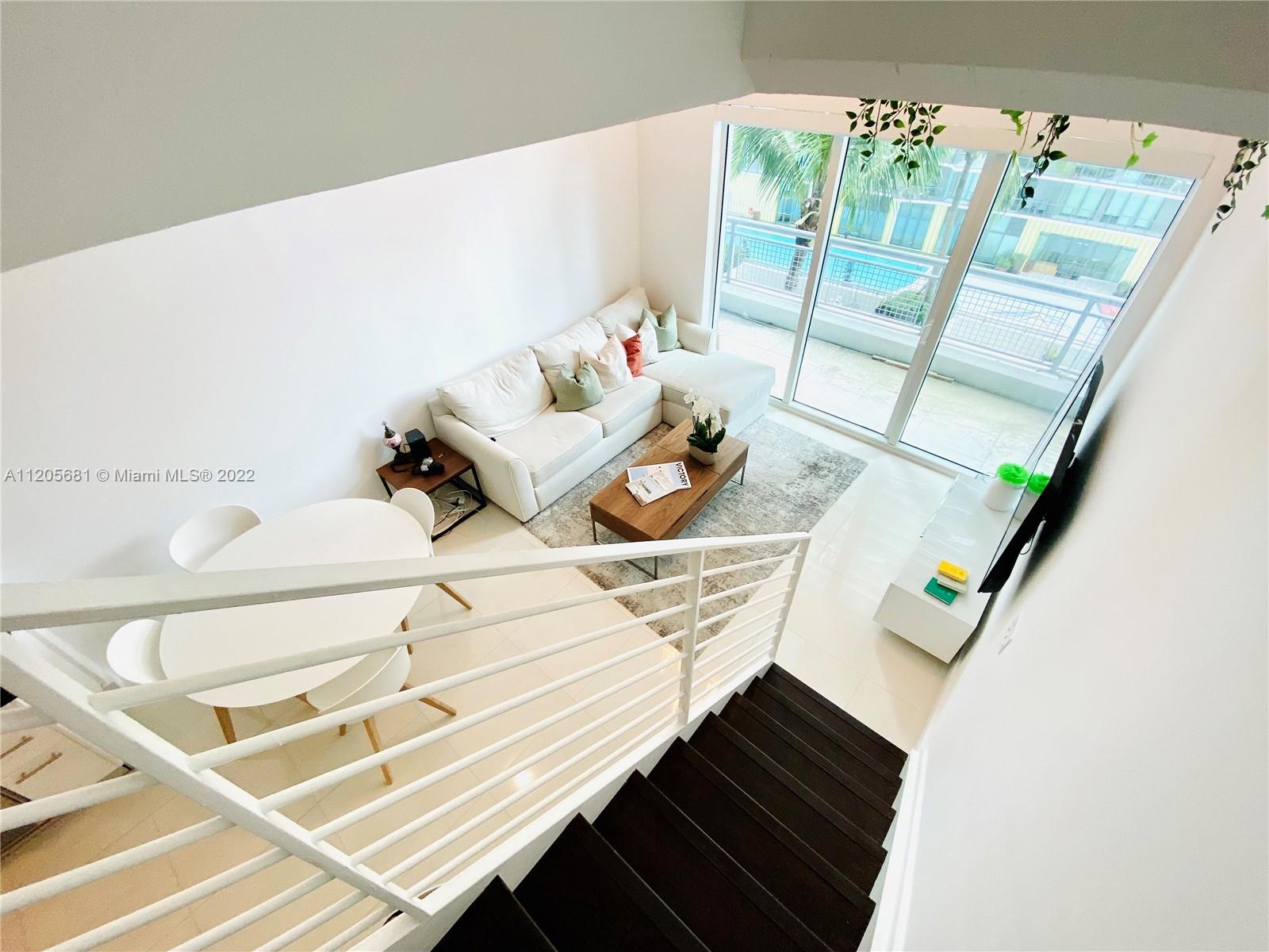 60 Southwest 13th Street, Unit 1412 Miami, FL 33130 - Photo 18 of 39 a living room with furniture and a floor to ceiling window