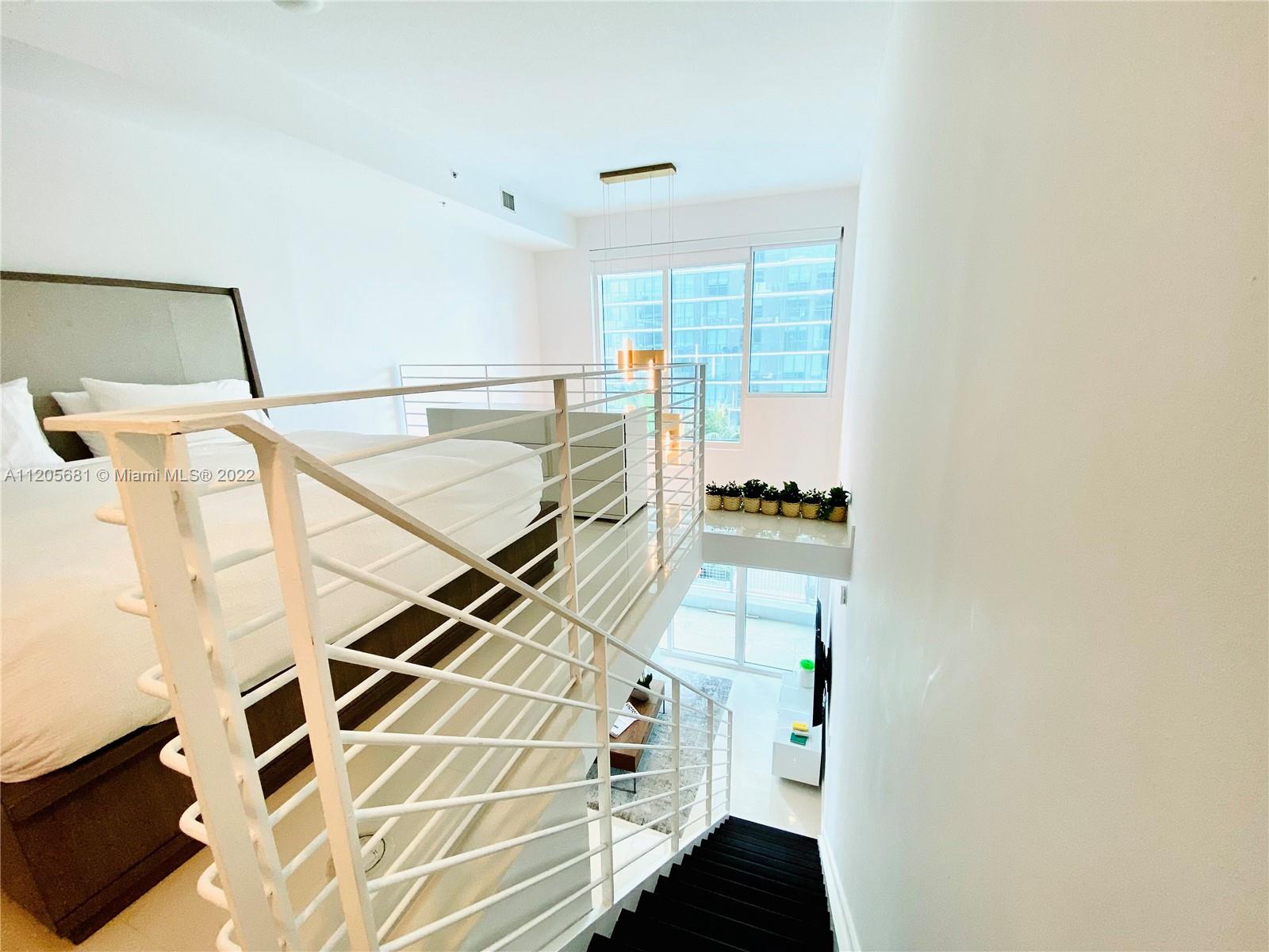 60 Southwest 13th Street, Unit 1412 Miami, FL 33130 - Photo 19 of 39 a picture of a room with wooden floor and windows